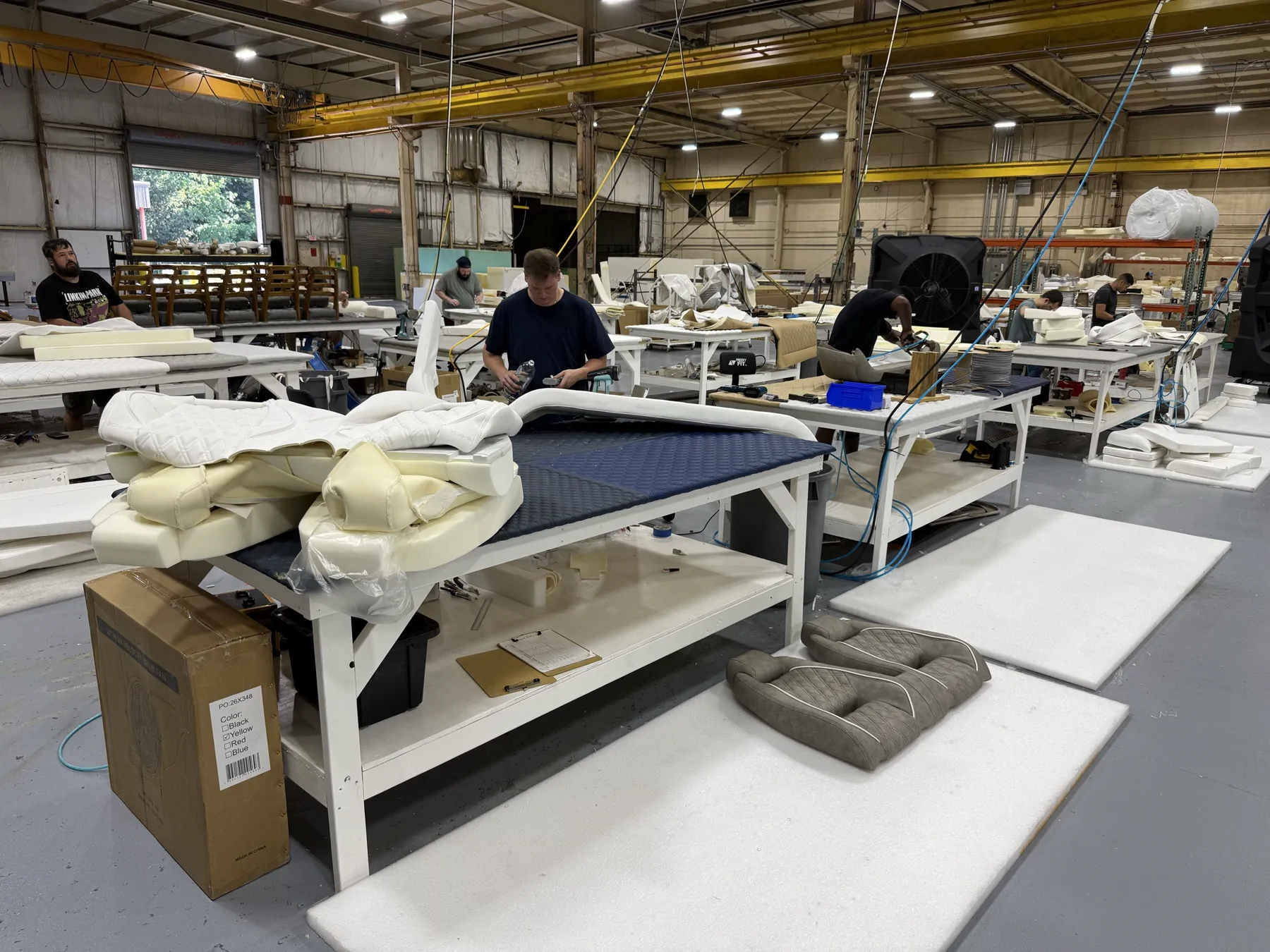 Marine upholstery craftspeople working across the Blue Core Craft production floor