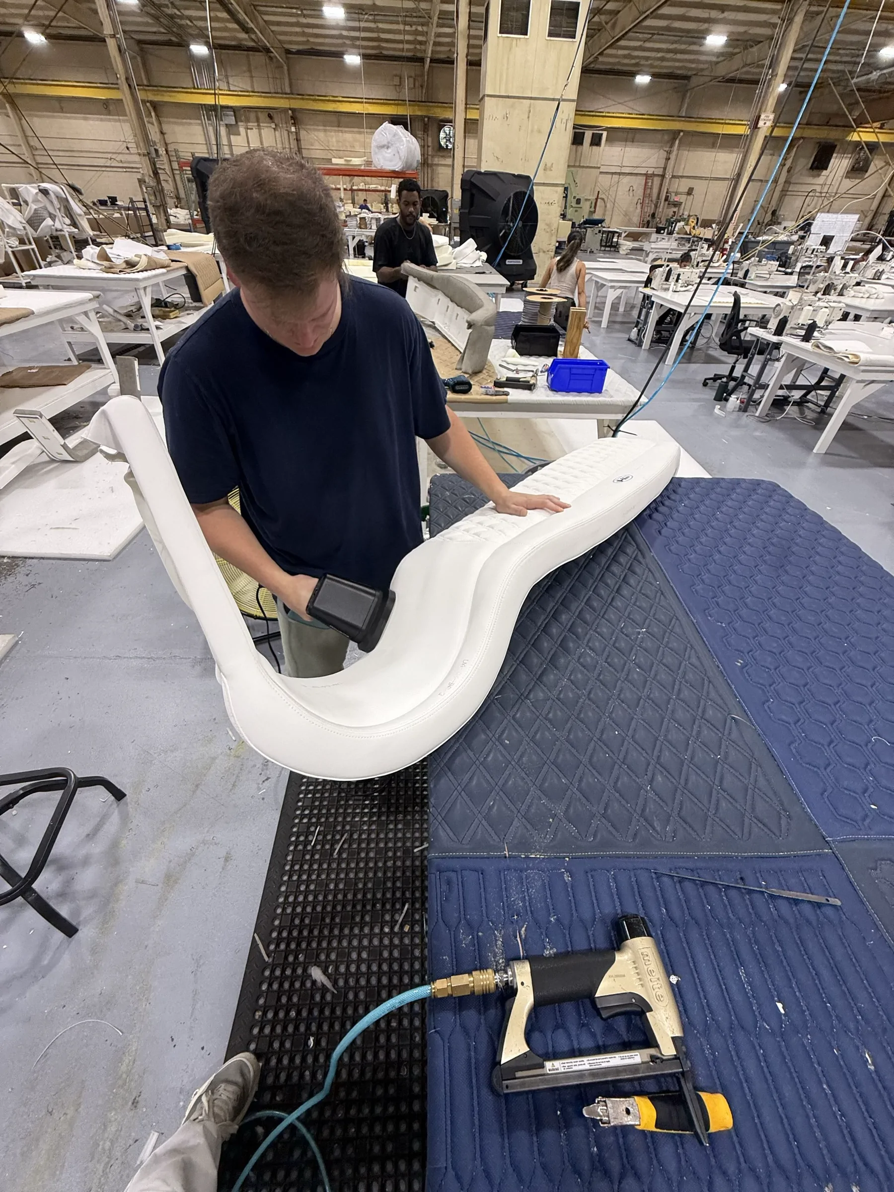 Craftsperson inspecting a white marine upholstery component